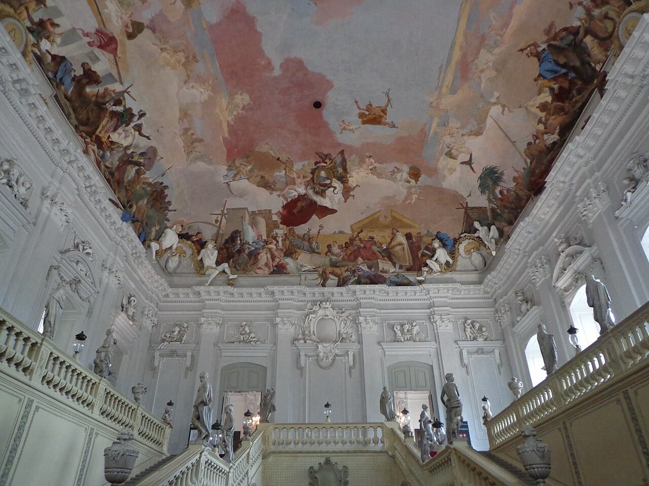 The Treppenhaus of the Würzburg Residence rising toward Tiepolo's Apollo and the Four Continents ceiling fresco over Neumann's column-free trough vault