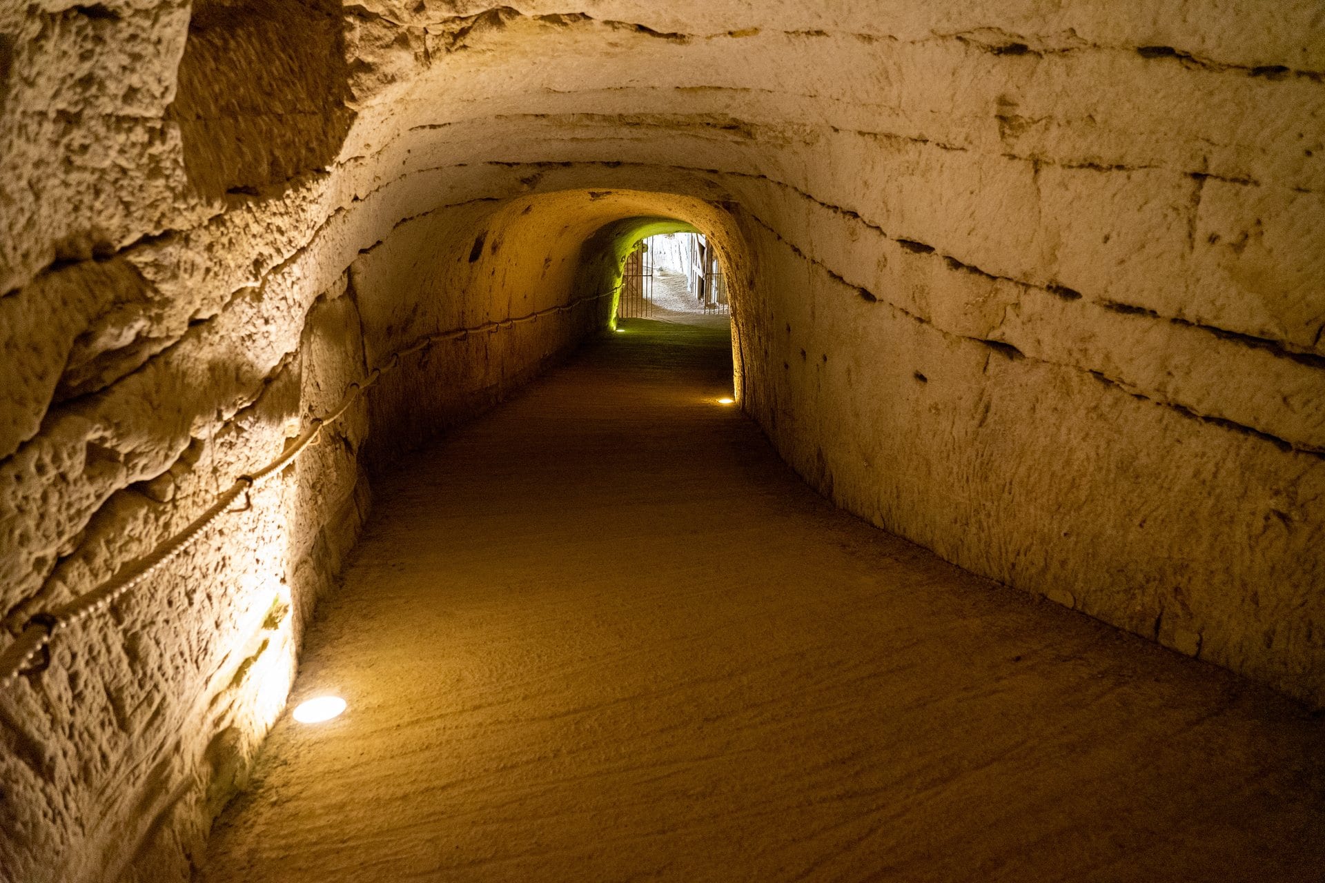 A lamplit underground gallery beneath Château de Brézé
