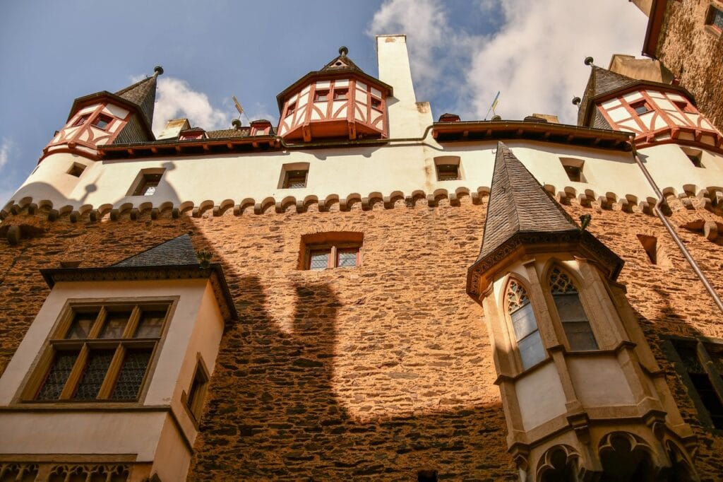 Courtyard of Burg Eltz with red-and-white half-timbered oriels and the Gothic chapel bay window