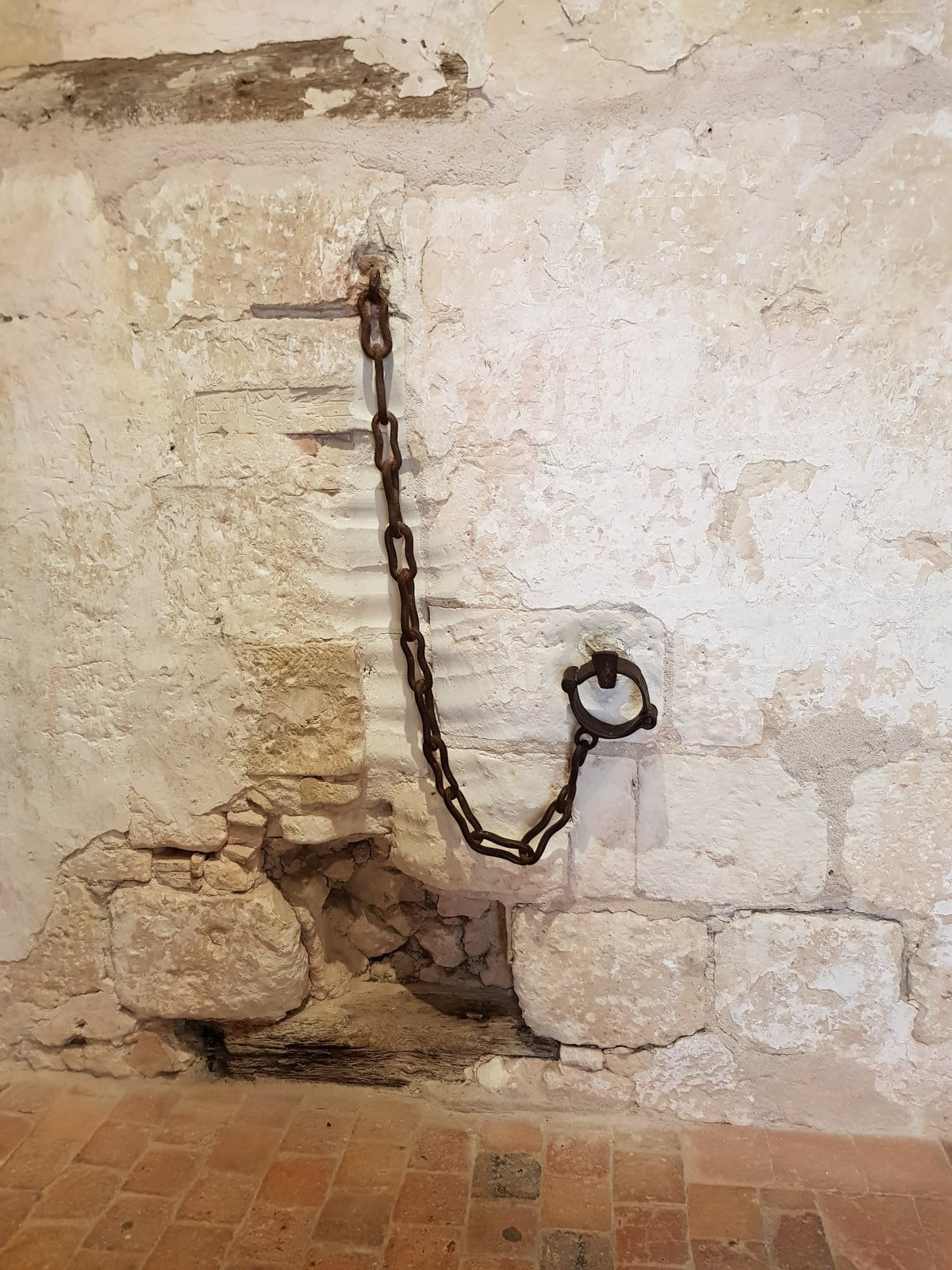 A bare stone prison cell in the fortress of Loches with an iron chain bolted to the wall. A bare stone prison cell in the fortress of Loches with an iron chain bolted to the wall.