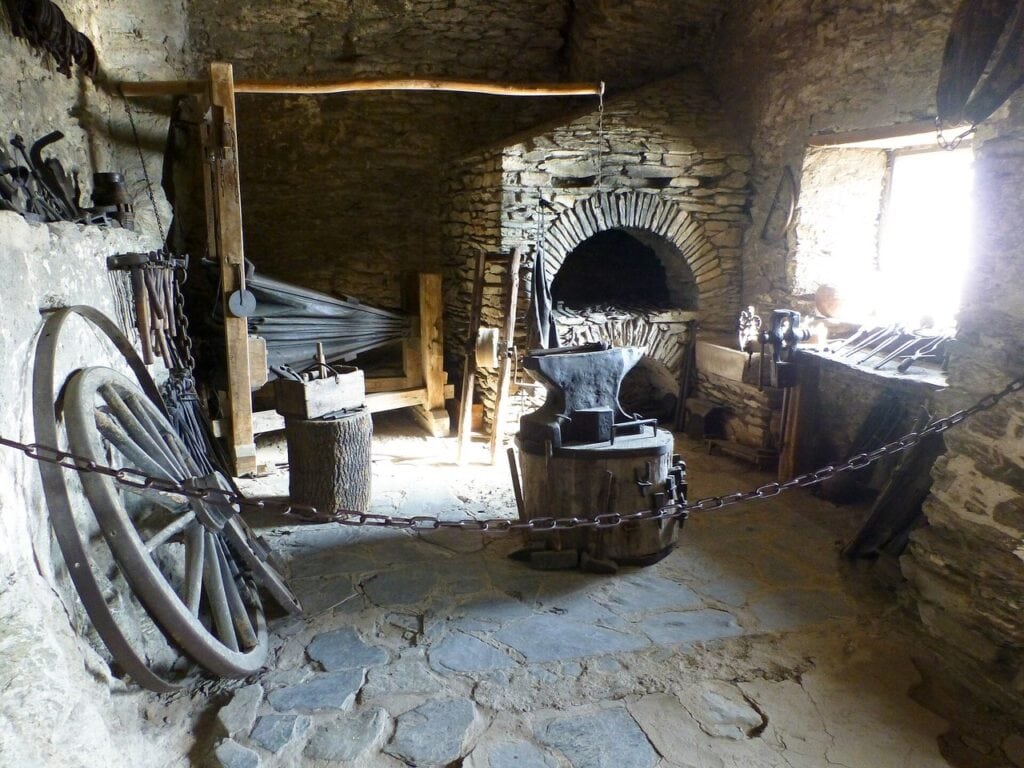 The forge at Marksburg with an anvil before a brick-arched hearth in a rock chamber