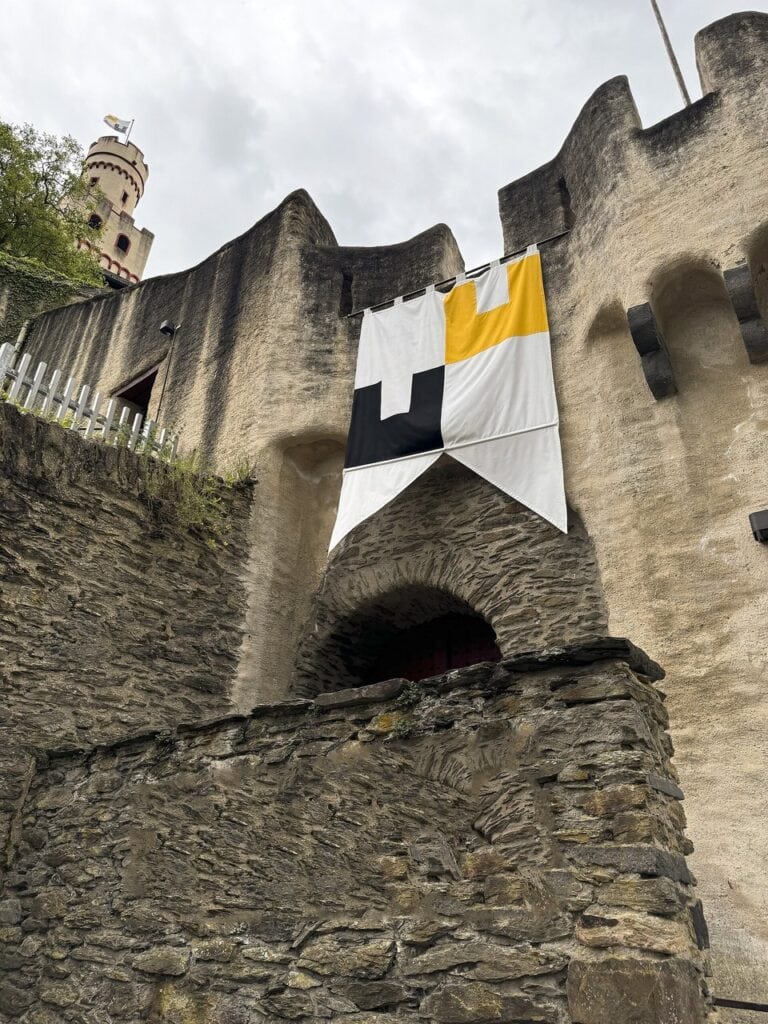 Marksburg gate tower from below, crenellated parapet on stone corbels above the arch