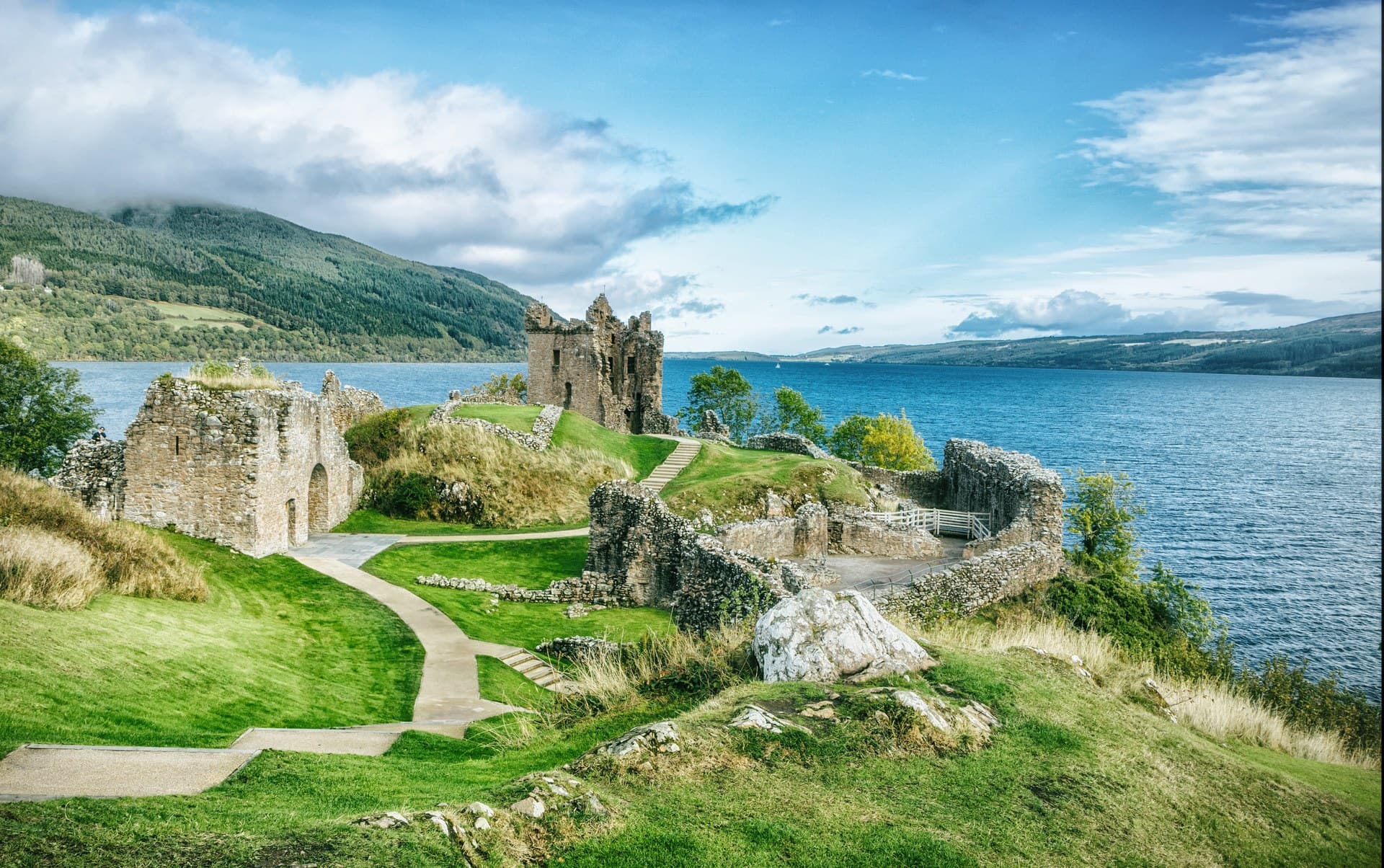 Urquhart Castle stretches along its rocky promontory on Loch Ness, its towers and baileys linked by the visitor path. Urquhart Castle stretches along its rocky promontory on Loch Ness, its towers and baileys linked by the visitor path.