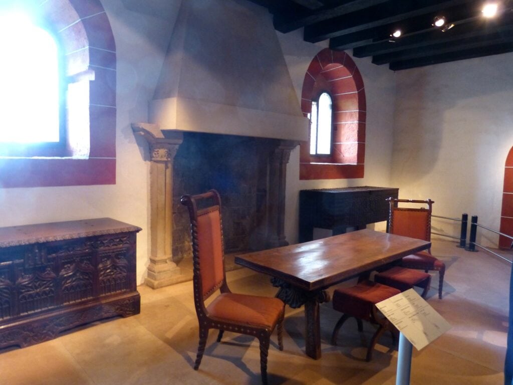 The dining hall of Wartburg Castle with its Romanesque fireplace and carved chests