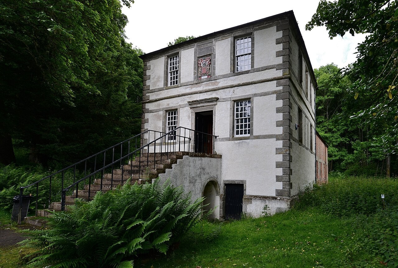 A two-storey harled pavilion with rusticated stone quoins, twelve-pane sash windows and a carved armorial panel between the upper windows, entered by a straight external stone stair with iron railings rising to a first-floor door. A two-storey harled pavilion with rusticated stone quoins, twelve-pane sash windows and a carved armorial panel between the upper windows, entered by a straight external stone stair with iron railings rising to a first-floor door.