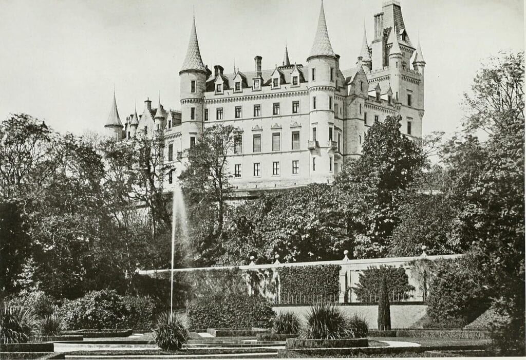 Dunrobin Castle 6 A halftone photograph of the castle's long garden front seen across the formal gardens, with a tall fountain jet playing in a pool in the foreground.
