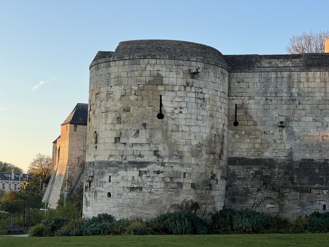 A round barbican drum at the Château de Caen with keyhole gun-loops, each a vertical slit ending in a circular opening, cut through the ashlar. A round barbican drum at the Château de Caen with keyhole gun-loops, each a vertical slit ending in a circular opening, cut through the ashlar.