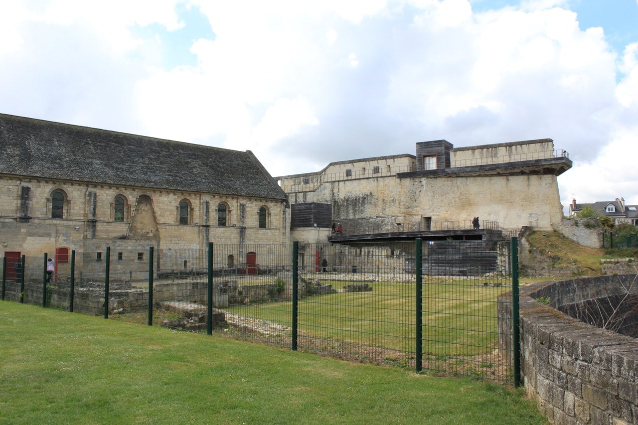 The Salle de l'Échiquier at left, low excavated wall footings of the ducal palace across the middle ground, and the faced artillery terrace with a modern timber viewing deck at right. The Salle de l'Échiquier at left, low excavated wall footings of the ducal palace across the middle ground, and the faced artillery terrace with a modern timber viewing deck at right.