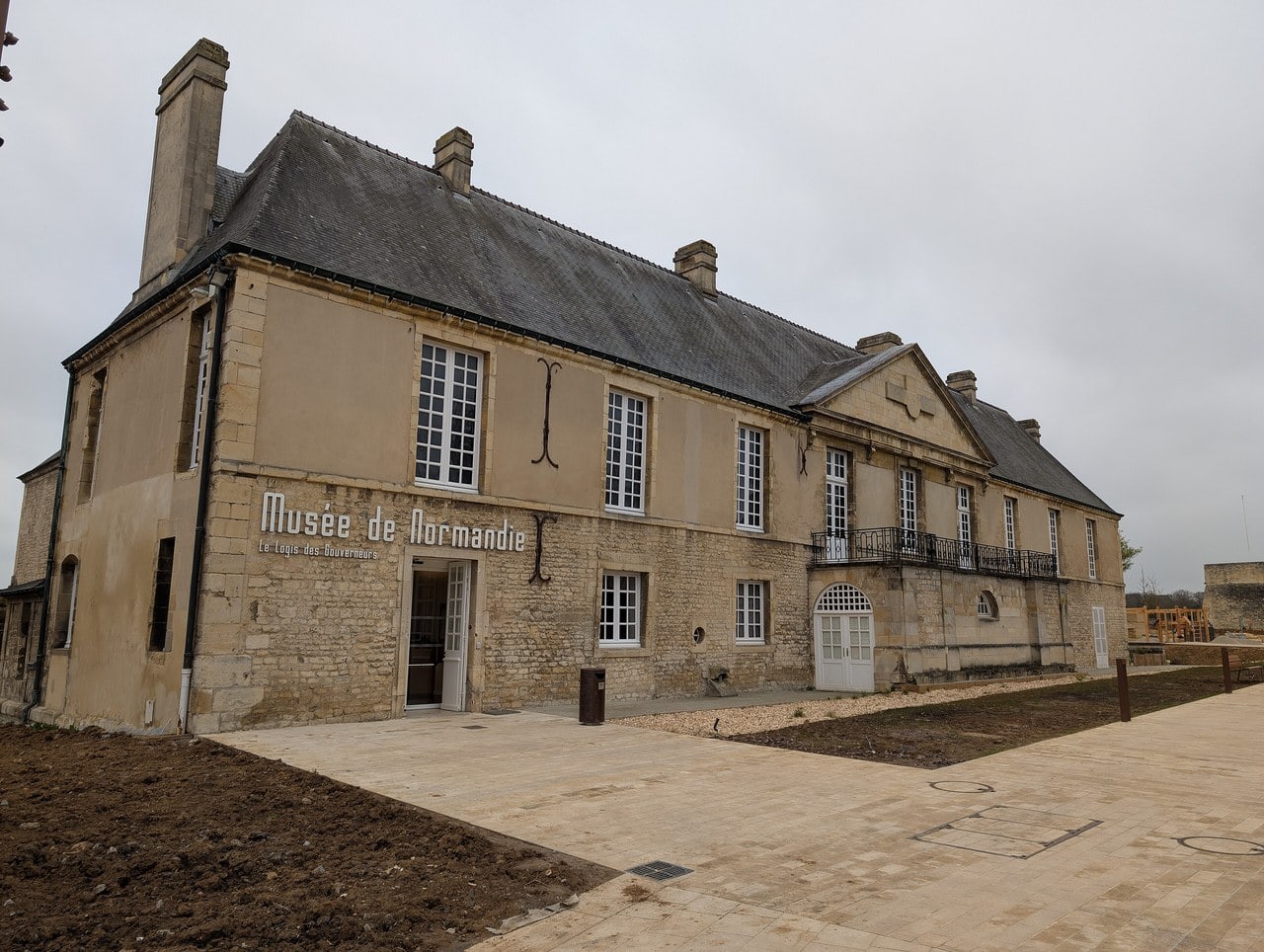 The Logis des Gouverneurs at the Château de Caen, a long stone range with tall multi-pane windows and a slate roof, lettered Musée de Normandie across its facade. The Logis des Gouverneurs at the Château de Caen, a long stone range with tall multi-pane windows and a slate roof, lettered Musée de Normandie across its facade.