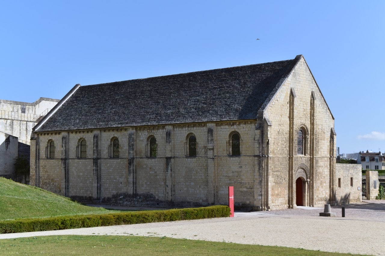 The exterior of the Salle de l'Échiquier at the Château de Caen, a long stone hall with two registers of round-arched windows, pilaster buttresses and a carved doorway in its gable. The exterior of the Salle de l'Échiquier at the Château de Caen, a long stone hall with two registers of round-arched windows, pilaster buttresses and a carved doorway in its gable.