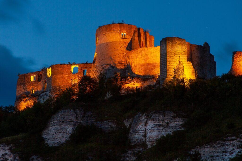 Château Gaillard 6 Château Gaillard floodlit orange against a deep blue evening sky, the donjon rising behind the inner curtain.