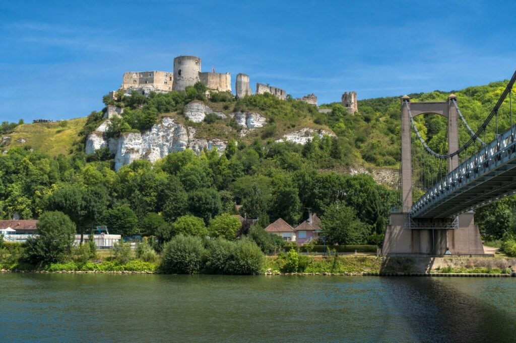 Château Gaillard 9 Château Gaillard along the top of a white chalk cliff over the Seine, the suspension bridge at Les Andelys crossing the river in the foreground.