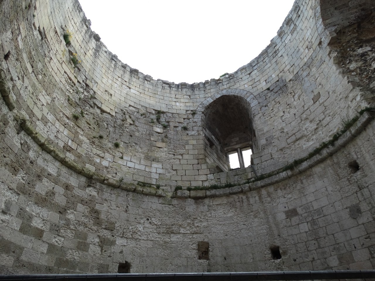 The interior of Château Gaillard's donjon, a circular wall of coursed stone rising to an open top, with a deeply splayed window embrasure holding a two-light window. The interior of Château Gaillard's donjon, a circular wall of coursed stone rising to an open top, with a deeply splayed window embrasure holding a two-light window.