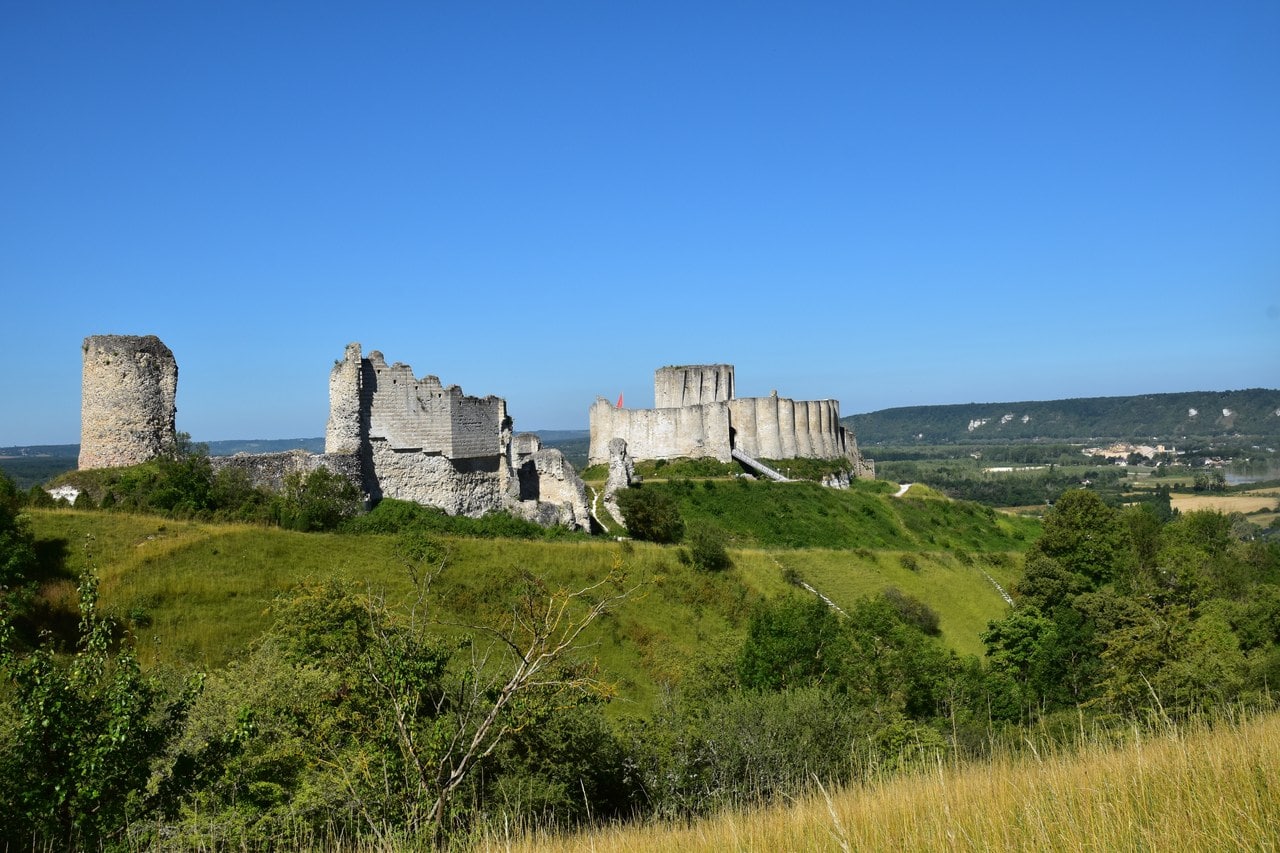 The whole of Château Gaillard seen along the length of its chalk spur, the advance work's round tower at left and the donjon at right, with open country beyond. The whole of Château Gaillard seen along the length of its chalk spur, the advance work's round tower at left and the donjon at right, with open country beyond.