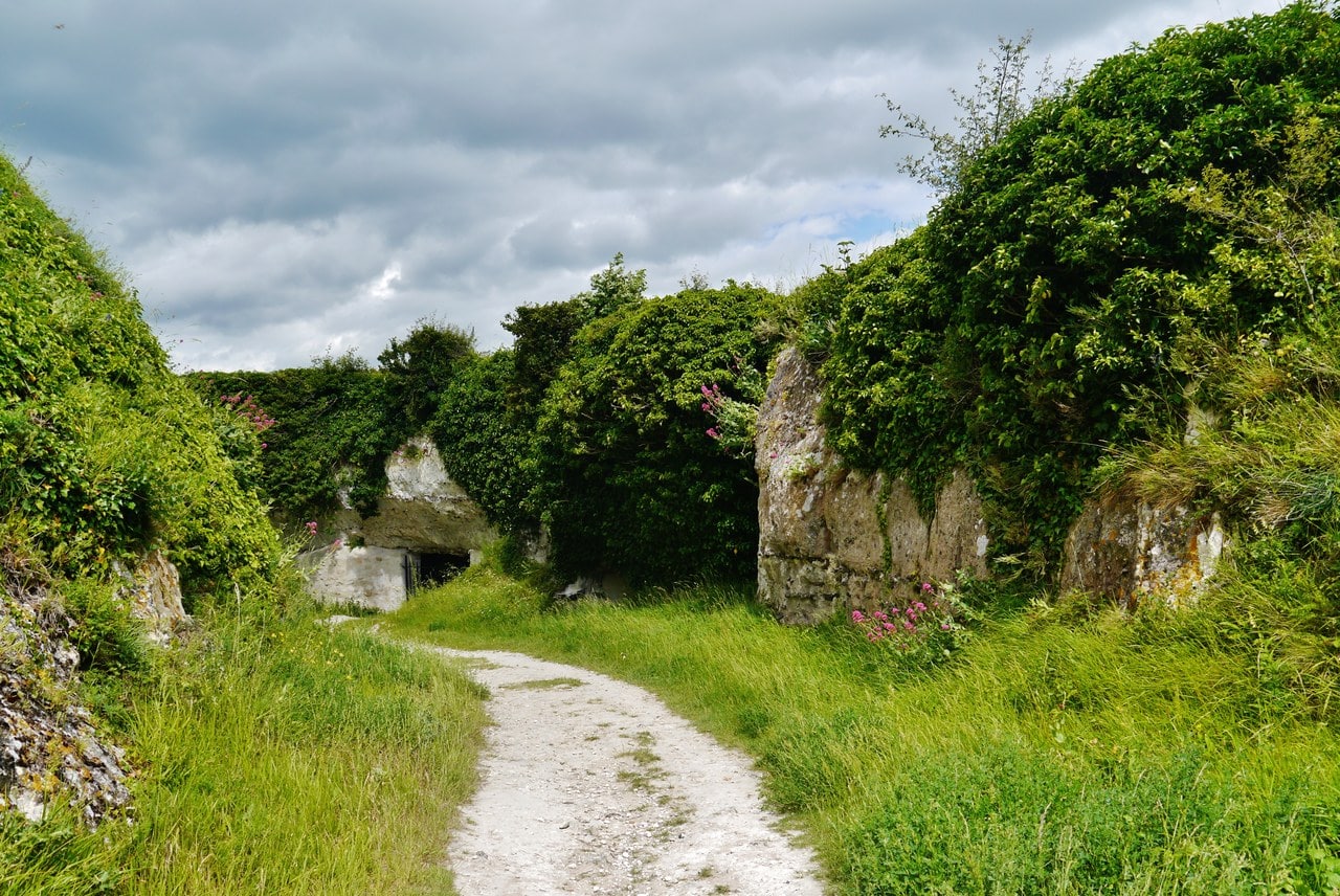 A dry ditch at Château Gaillard cut down through white chalk, with a footpath along its floor and a rock-cut chamber in the left-hand face closed with masonry. A dry ditch at Château Gaillard cut down through white chalk, with a footpath along its floor and a rock-cut chamber in the left-hand face closed with masonry.