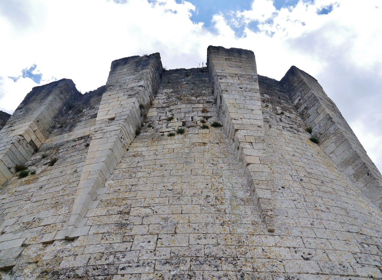 The face of Château Gaillard's donjon seen from below, a row of tall buttresses rising from a steeply battered plinth to a broken wall head. The face of Château Gaillard's donjon seen from below, a row of tall buttresses rising from a steeply battered plinth to a broken wall head.