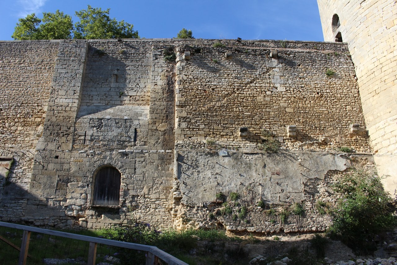 A curtain wall at Chateau de Gisors seen from below, a straight vertical joint separating a stretch of large squared blocks from a stretch of small coarse rubble masonry. A curtain wall at Chateau de Gisors seen from below, a straight vertical joint separating a stretch of large squared blocks from a stretch of small coarse rubble masonry.