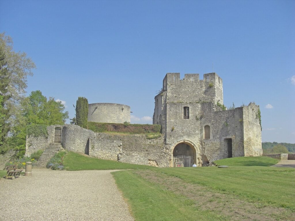 Château de Gisors 4 The gatehouse and cylindrical great tower of Chateau de Gisors seen across mown grass from the park path, with the stone stair at the left.