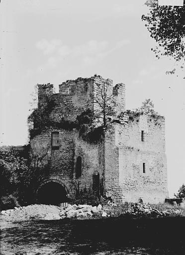 A black and white photograph of the gatehouse at Chateau de Gisors, saplings growing out of its broken wall head above a deep round-headed archway, with rubble heaped across the ground in front. A black and white photograph of the gatehouse at Chateau de Gisors, saplings growing out of its broken wall head above a deep round-headed archway, with rubble heaped across the ground in front.