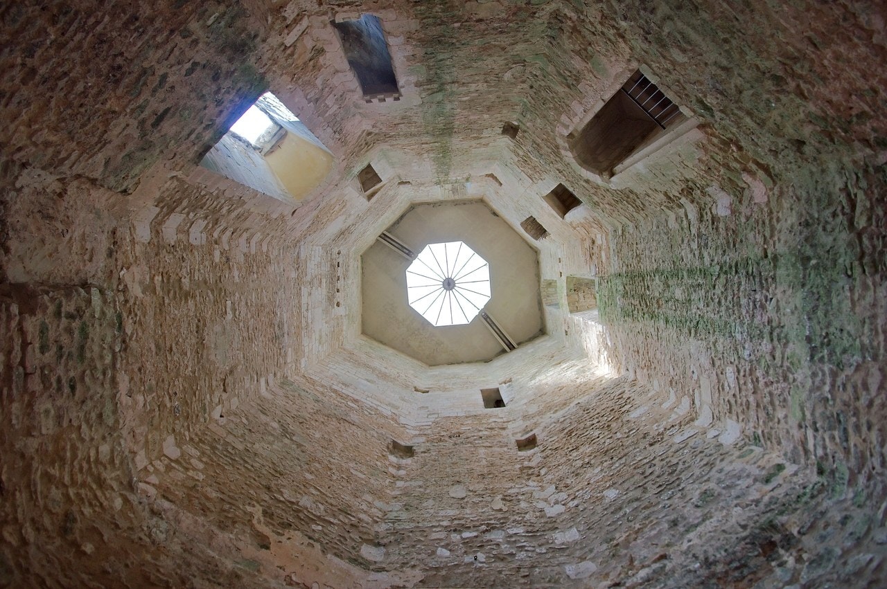 Looking straight up the hollow eight-sided interior of the keep at Chateau de Gisors, beam sockets in the rubble walls and a modern glazed lantern at the top. Looking straight up the hollow eight-sided interior of the keep at Chateau de Gisors, beam sockets in the rubble walls and a modern glazed lantern at the top.