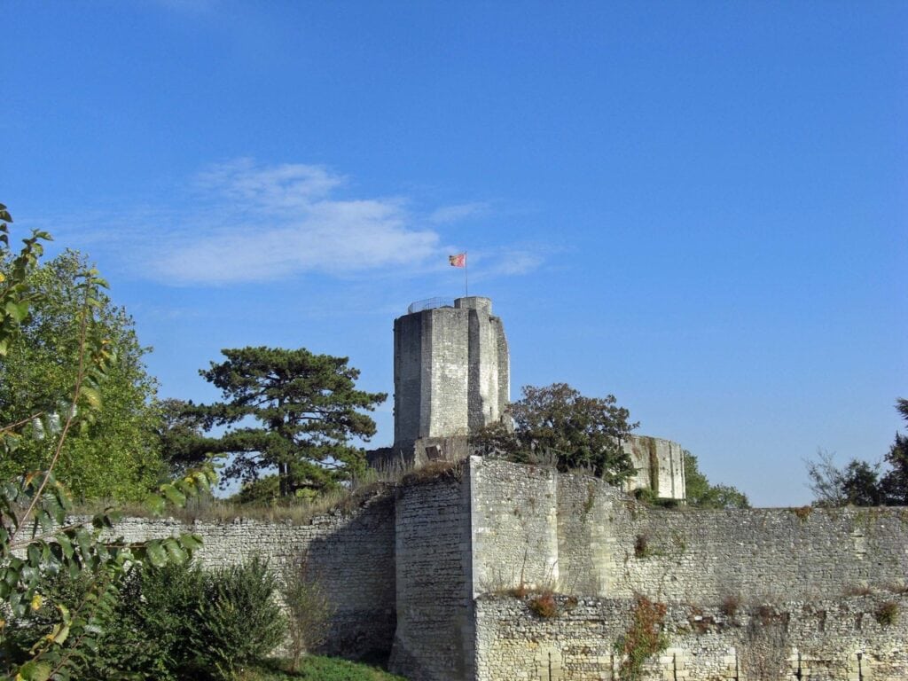 Château de Gisors 5 The octagonal keep of Chateau de Gisors above a long buttressed curtain wall, seen from outside the enclosure.