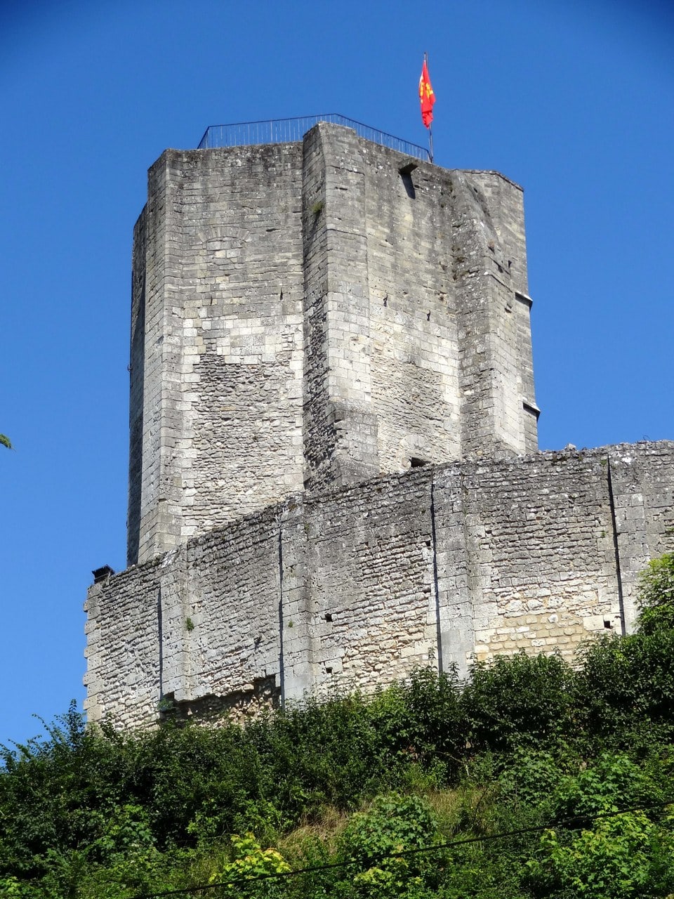 The octagonal great tower on the motte at Chateau de Gisors seen close from below, its angled wall faces meeting at sharp edges and a polygonal stair turret at one corner. The octagonal great tower on the motte at Chateau de Gisors seen close from below, its angled wall faces meeting at sharp edges and a polygonal stair turret at one corner.