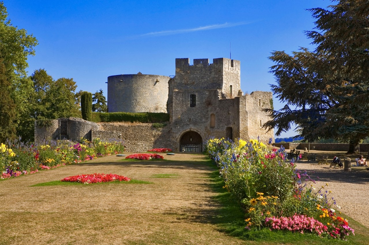 Massed flowerbeds and mown lawn in the park at Chateau de Gisors, leading to the crenellated gatehouse with the cylindrical great tower behind. Massed flowerbeds and mown lawn in the park at Chateau de Gisors, leading to the crenellated gatehouse with the cylindrical great tower behind.