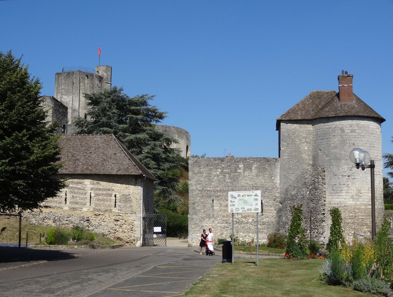 The town-side entrance to Chateau de Gisors, with an interpretation panel beside the path and a round tower under a conical tiled roof at the corner of the wall. The town-side entrance to Chateau de Gisors, with an interpretation panel beside the path and a round tower under a conical tiled roof at the corner of the wall.