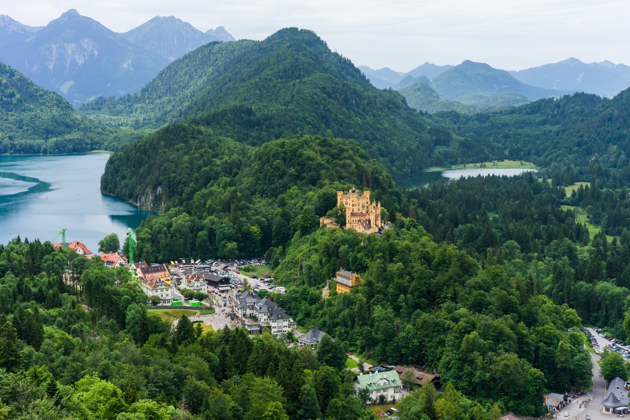 Hohenschwangau Castle on its wooded hill with the Alpsee to the left and the smaller Schwansee to the right, the village of Hohenschwangau below Hohenschwangau Castle on its wooded hill with the Alpsee to the left and the smaller Schwansee to the right, the village of Hohenschwangau below