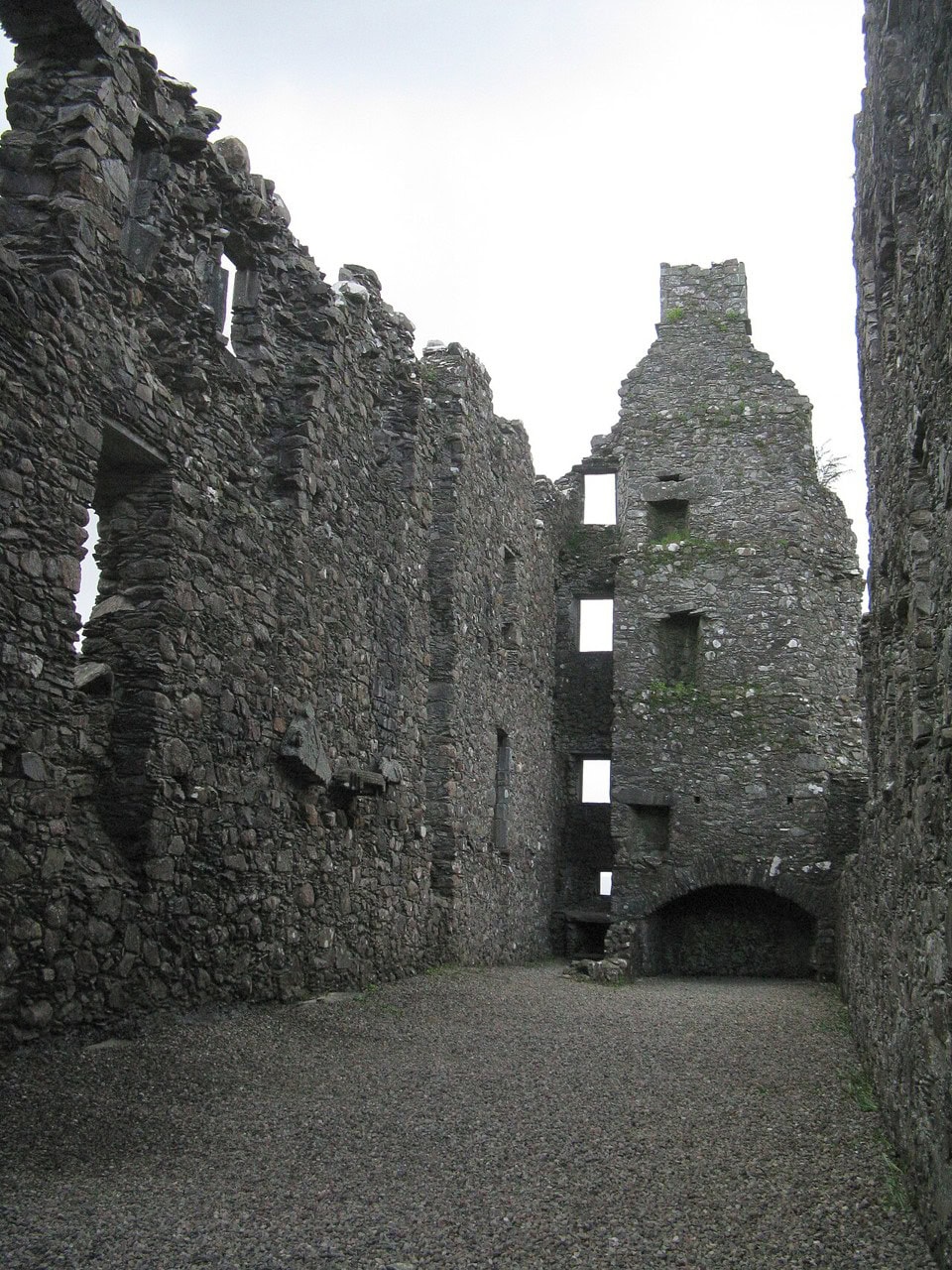 The long roofless interior of the barrack range at Kilchurn Castle, its standing side walls pierced by tiers of window openings above a gravelled floor. The long roofless interior of the barrack range at Kilchurn Castle, its standing side walls pierced by tiers of window openings above a gravelled floor.