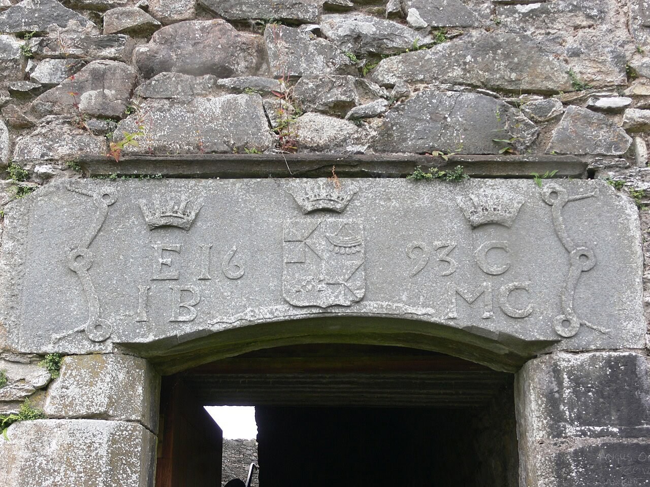 Close view of the carved entrance lintel at Kilchurn Castle, showing initials and the date 1693 split either side of a central shield, beneath three coronets. Close view of the carved entrance lintel at Kilchurn Castle, showing initials and the date 1693 split either side of a central shield, beneath three coronets.