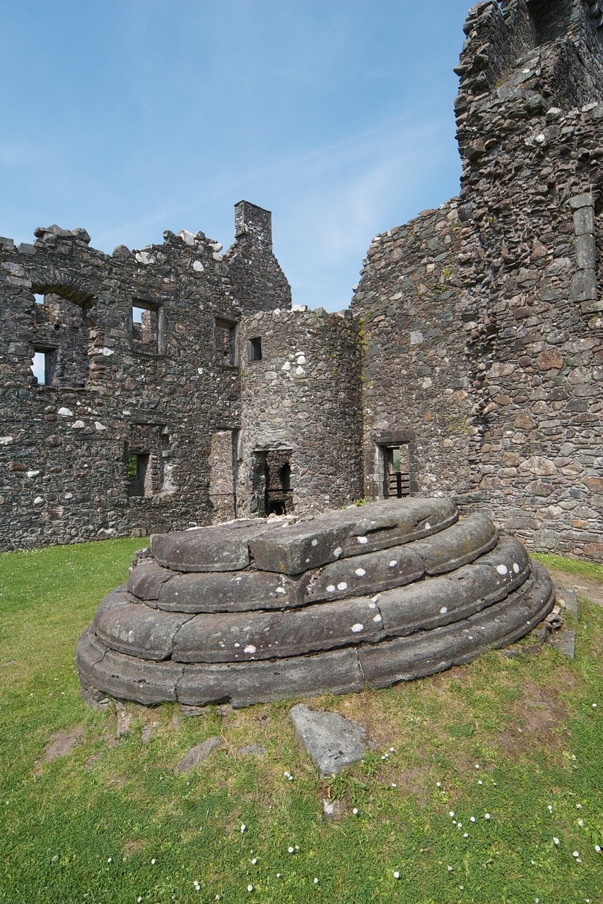A fallen corbelled angle-turret lying upside down on the grass of Kilchurn Castle's courtyard, its concentric corbel courses reading like a stack of stone steps, with roofless ranges behind. A fallen corbelled angle-turret lying upside down on the grass of Kilchurn Castle's courtyard, its concentric corbel courses reading like a stack of stone steps, with roofless ranges behind.