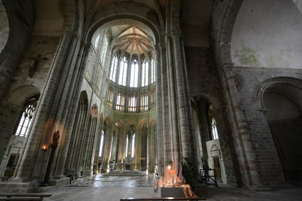 Mont-Saint-Michel 12 Looking east from the crossing of Mont-Saint-Michel abbey church into the Gothic choir, with the Romanesque work of the nave at the right of the frame: a massive round pier and a round-headed arch.