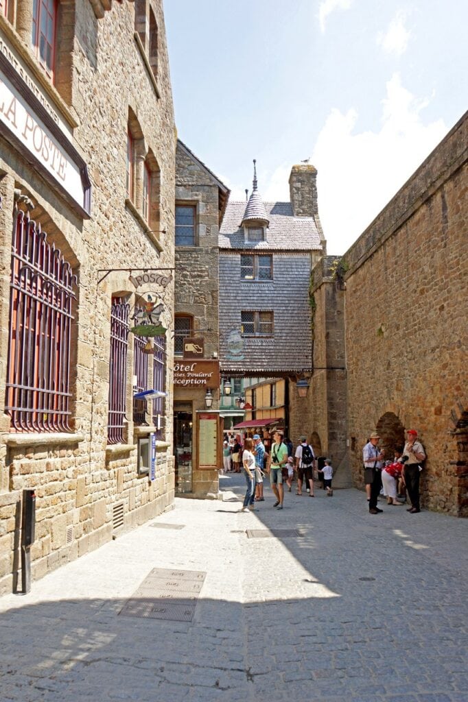 Mont-Saint-Michel 21 Visitors filling a narrow street between tall stone houses on Mont-Saint-Michel