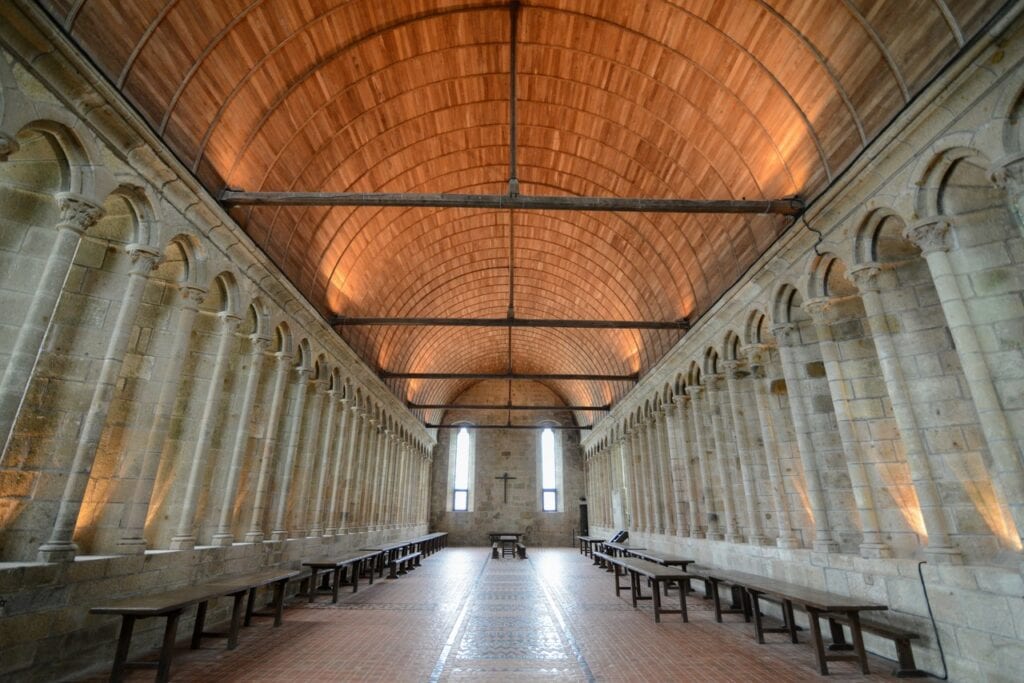 Mont-Saint-Michel 14 The long refectory of Mont-Saint-Michel under a timber barrel roof, with benches and tables down its length