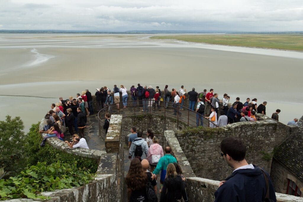 Mont-Saint-Michel 4 Visitors standing on the round platform of the tour du Nord, looking out over sand flats and shallow water