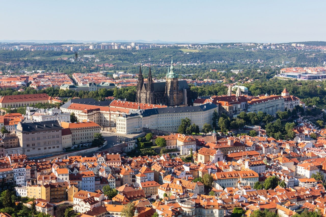 Prague Castle seen from Petřín hill: a long palace front runs the width of the frame along the top of its ridge, with the towers of St Vitus Cathedral rising behind it and the roofs of the Malá Strana below. Prague Castle seen from Petřín hill: a long palace front runs the width of the frame along the top of its ridge, with the towers of St Vitus Cathedral rising behind it and the roofs of the Malá Strana below.