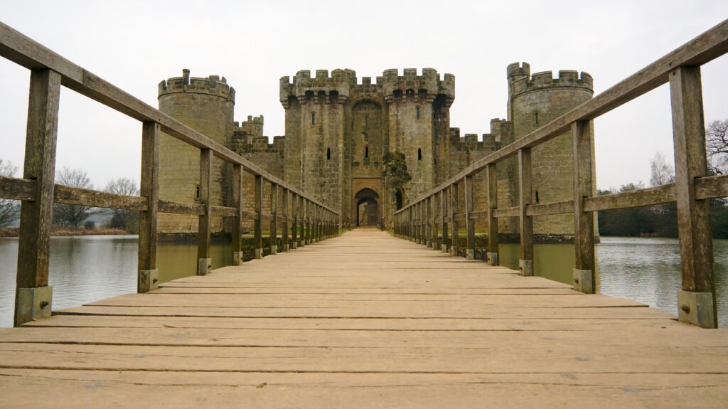 Wooden bridge deck over the moat at Bodiam Castle leading towards the castle entrance