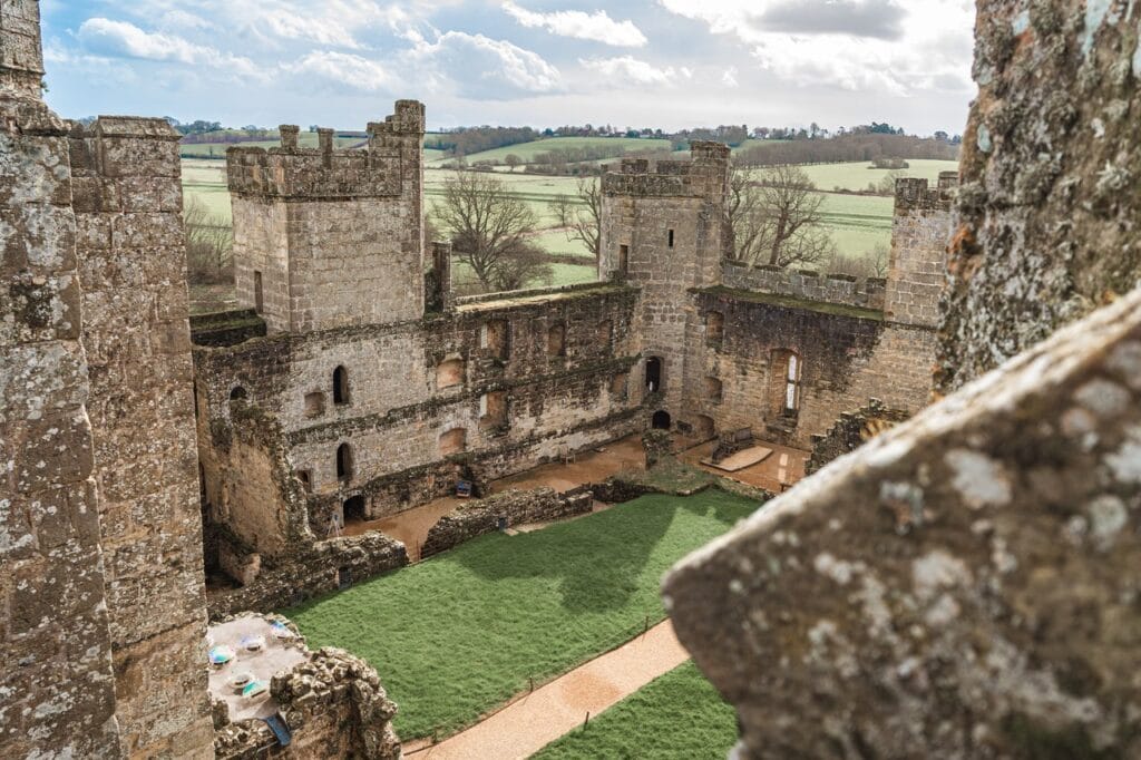 View down into Bodiam Castle courtyard from a tower top, foreground merlon in shadow