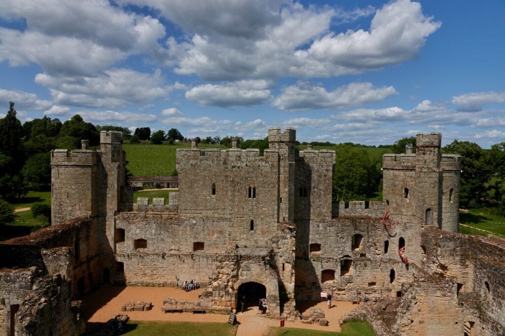 Grass courtyard of Bodiam Castle seen from high on the south side, looking to the inner face of the twin-towered gatehouse and the roofless north range