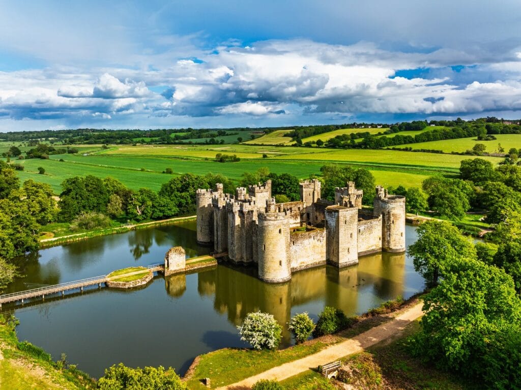 Aerial view of Bodiam Castle surrounded by its rectangular moat in green farmland
