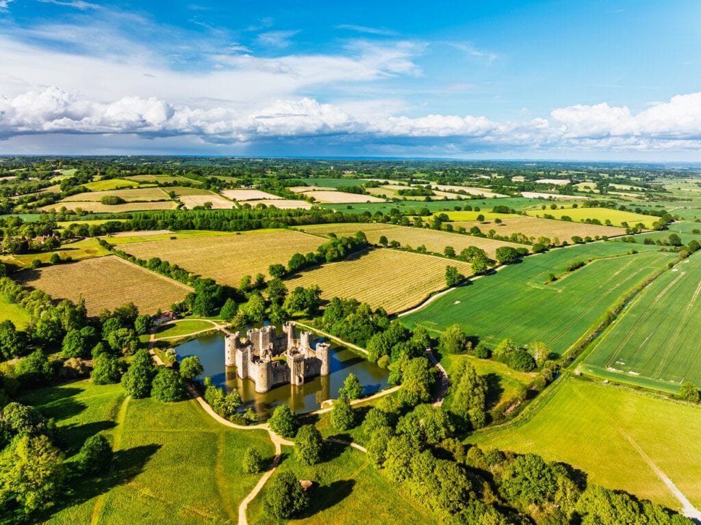 High aerial of Bodiam Castle and its moat set among hedged fields