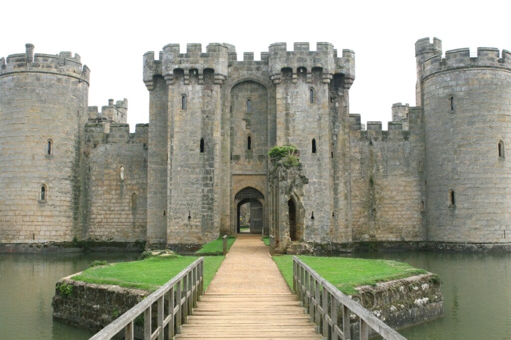 Symmetrical view of the north front of Bodiam Castle with a wooden bridge crossing the moat
