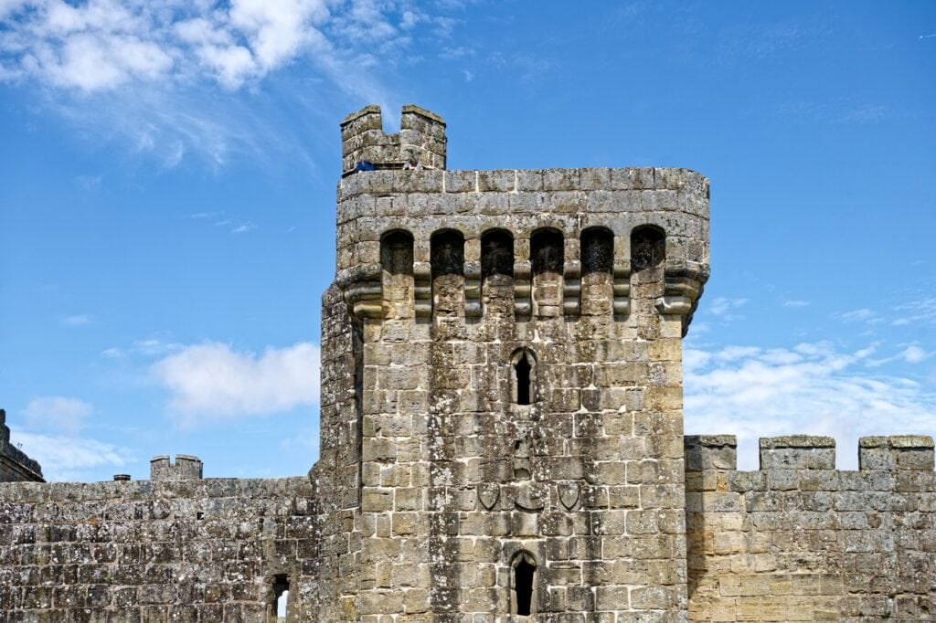 Square postern tower at Bodiam Castle with a machicolated parapet, seen from outside the curtain