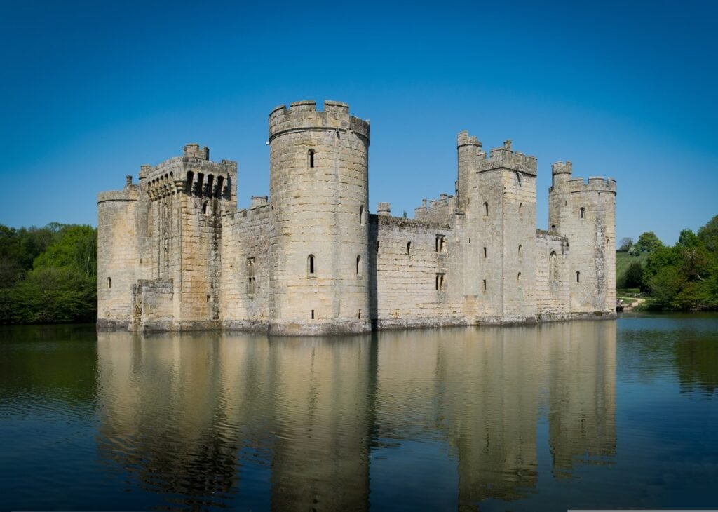 Bodiam Castle mirrored in the dark still surface of its moat