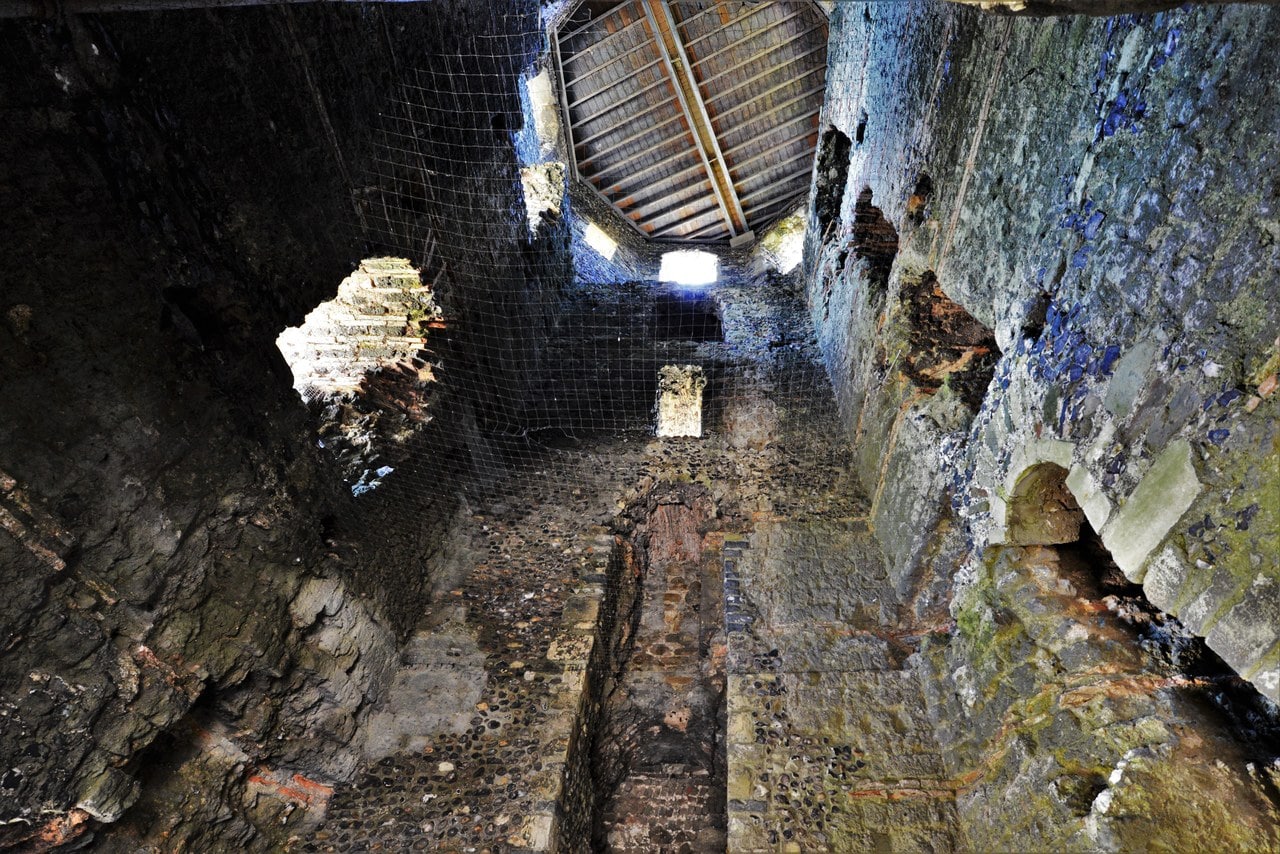 Looking up the hollow interior of the Roman pharos past protective netting to a timber roof. Looking up the hollow interior of the Roman pharos past protective netting to a timber roof.