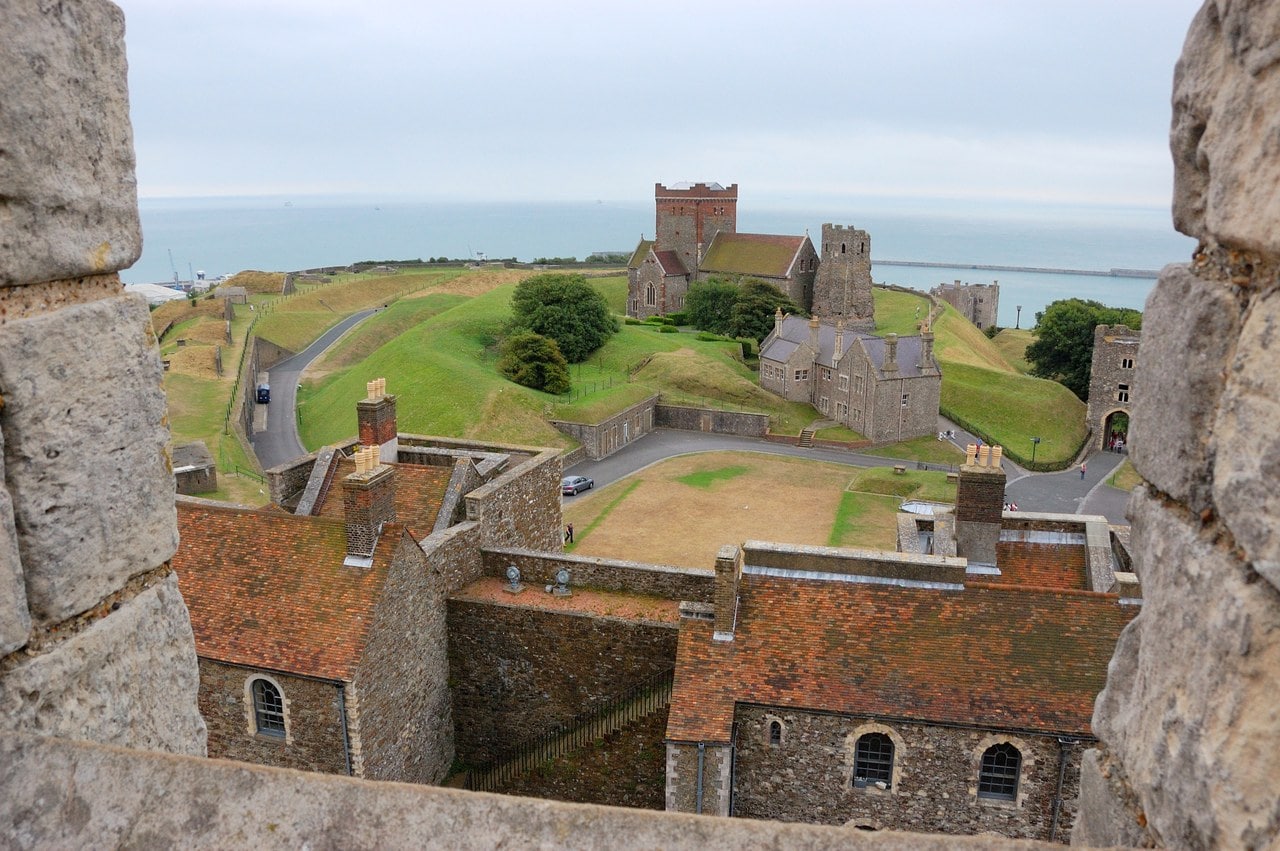 Looking down from the Great Tower's battlements over tiled roofs to the church and the ruined Roman pharos on the grass, with the sea beyond. Looking down from the Great Tower's battlements over tiled roofs to the church and the ruined Roman pharos on the grass, with the sea beyond.