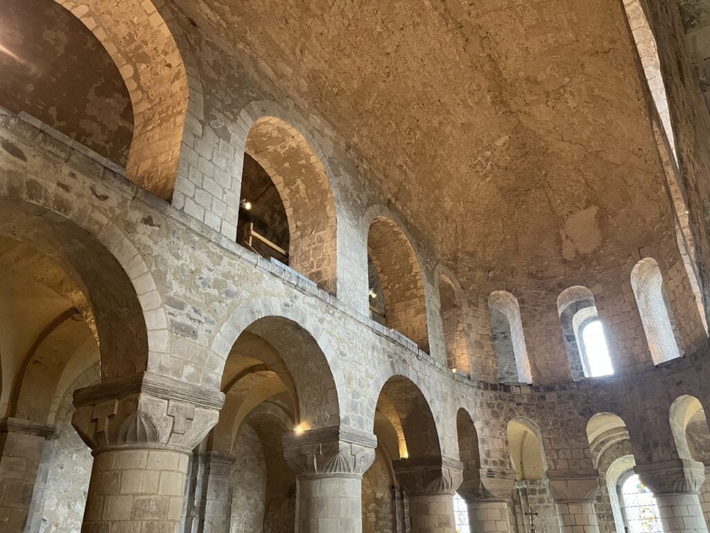 Looking up inside St John's Chapel: the round arches of the gallery above massive round piers, round-headed windows and the barrel vault.