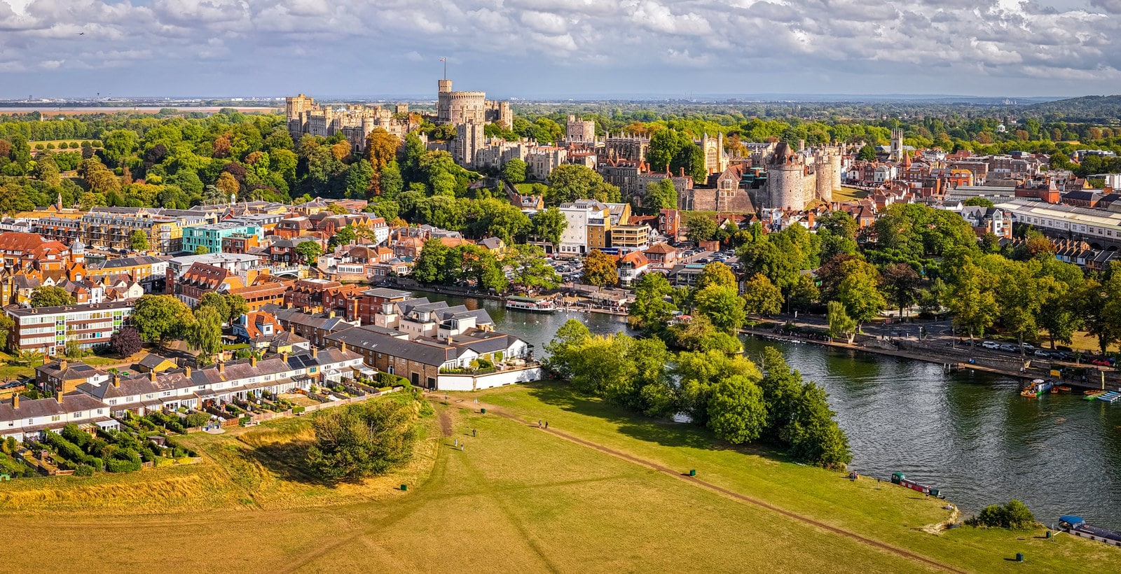 Windsor Castle 1 Aerial view of Windsor Castle on a low ridge above the roofs of the town, with the River Thames curving through open meadow in the foreground