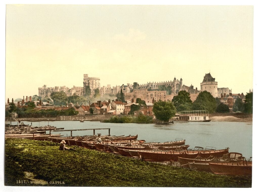 Windsor Castle 11 A color photochrom print of Windsor Castle on its ridge above the town, seen across the River Thames with wooden rowing boats moored in the foreground